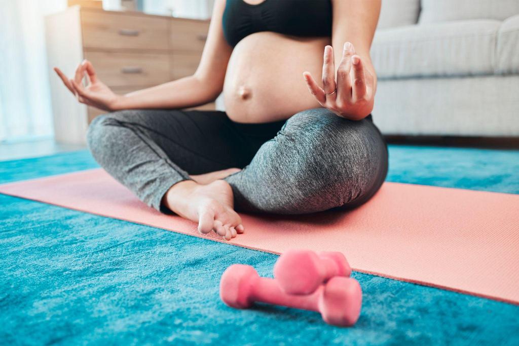 Pregnant woman practising yoga to manage stress and panic attacks during pregnancy.
