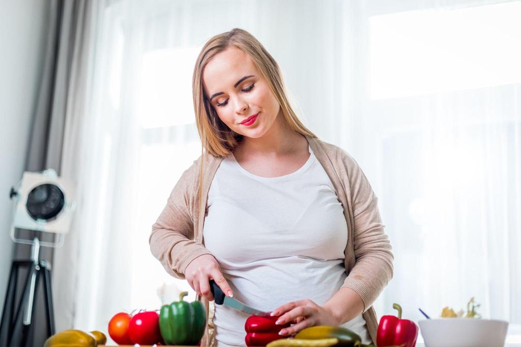 Pregnant woman preparing a nutritious meal, symbolising antenatal nutrition and foods that support baby's brain development.