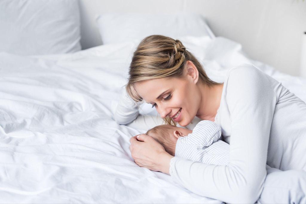 A mother bonding with her newborn, who is smiling for the first time.