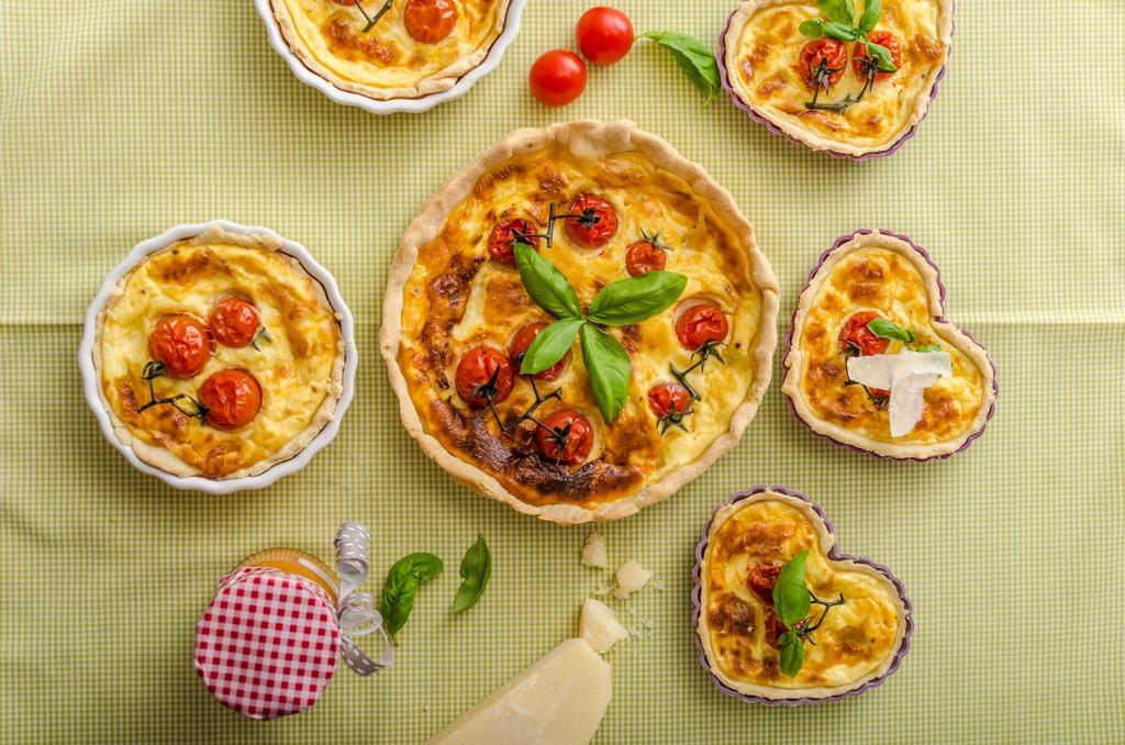 A pregnant woman enjoying a delicious and safe French meal, featuring quiche, steak, and fresh bread, in line with antenatal nutrition.