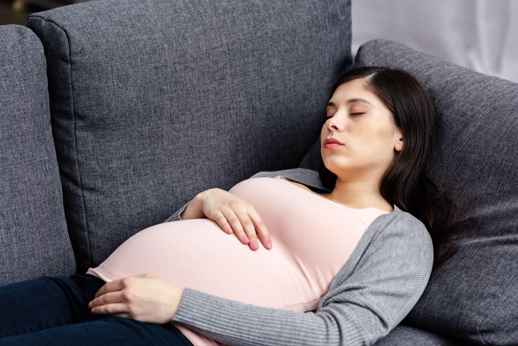 A pregnant woman feeling the discomfort of Braxton Hicks contractions in her third trimester at night.